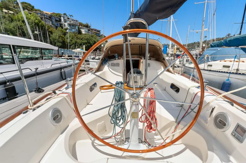 Slide: The Image of 2008 Sabre Spirit sailboat cockpit with wooden steering wheel, docked in a marina. - 27