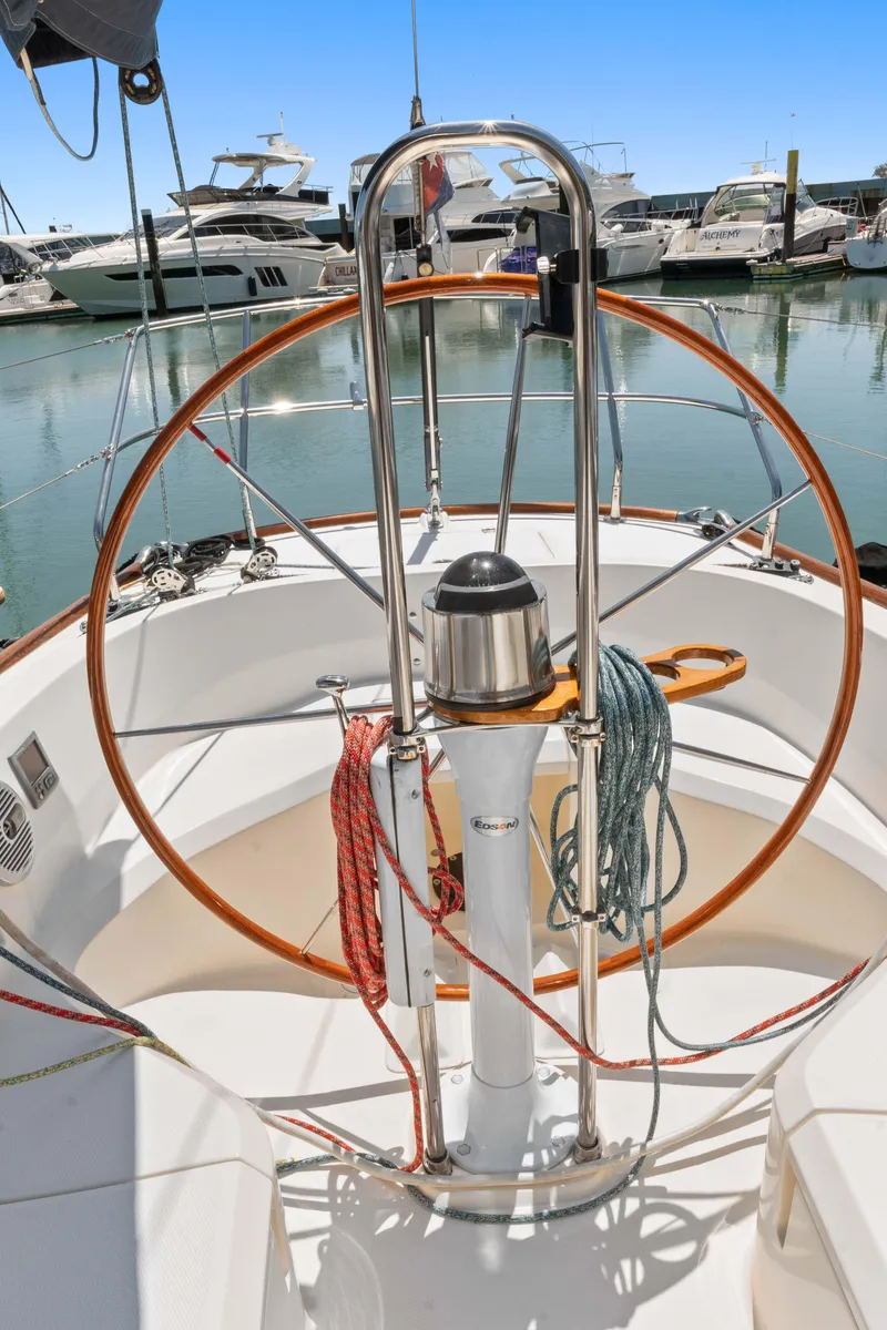 Slide: The Image of 2008 Sabre Spirit sailboat helm with wooden wheel and ropes, docked in marina. - 29