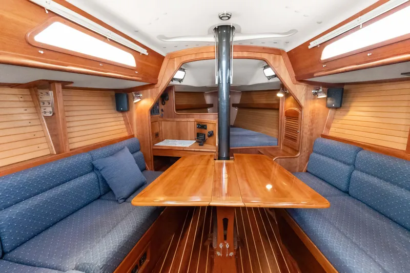 Slide: The Image of 2008 Sabre Spirit yacht interior with wooden table and blue cushioned seating. - 3