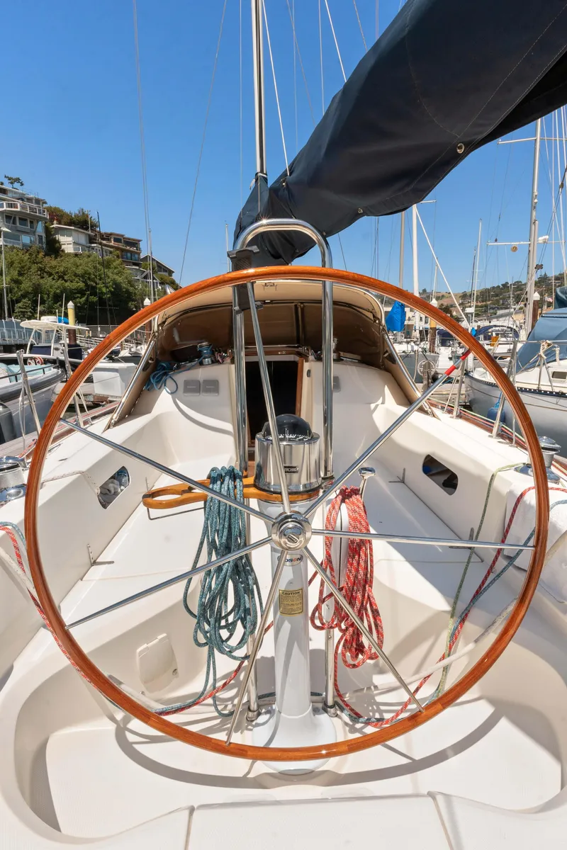 Slide: The Image of 2008 Sabre Spirit sailboat with wooden steering wheel in marina setting. - 30