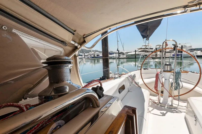 Slide: The Image of 2008 Sabre Spirit sailboat cockpit with marina view, featuring steering wheel and winch. - 47