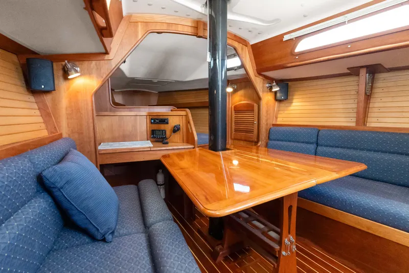 Slide: The Image of 2008 Sabre Spirit yacht interior with wooden table and blue cushioned seating. - 8