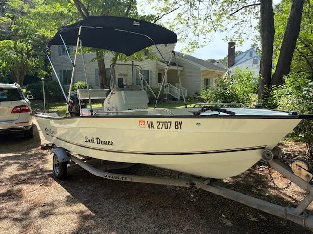Slide: The Image of 2013 Key Largo 160 Center Console boat on trailer, parked in a residential driveway. - 1