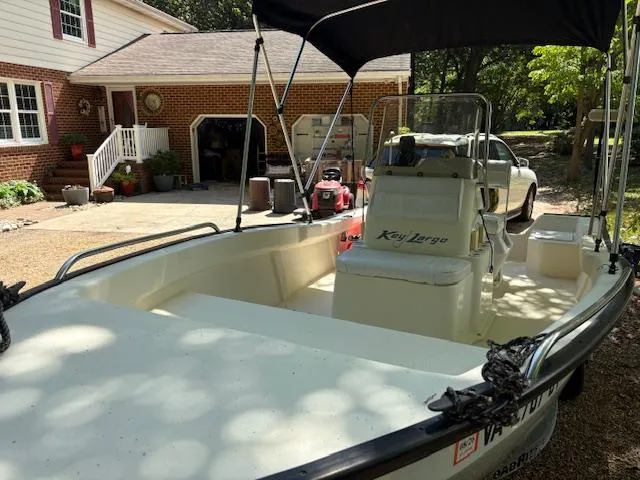 Slide: The Image of 2013 Key Largo 160 Center Console boat parked in a driveway near a brick house. - 2
