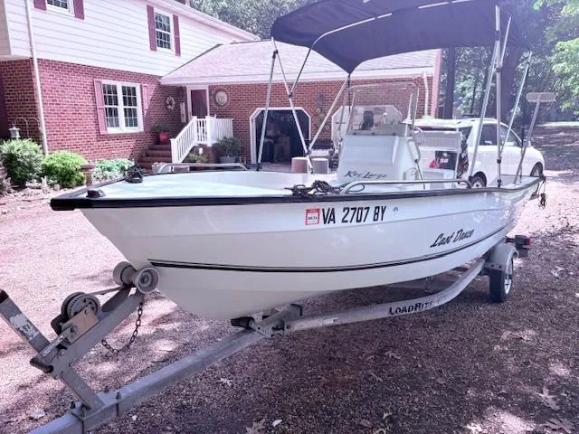 Slide: The Image of 2013 Key Largo 160 Center Console boat on trailer, parked in front of a brick house. - 3
