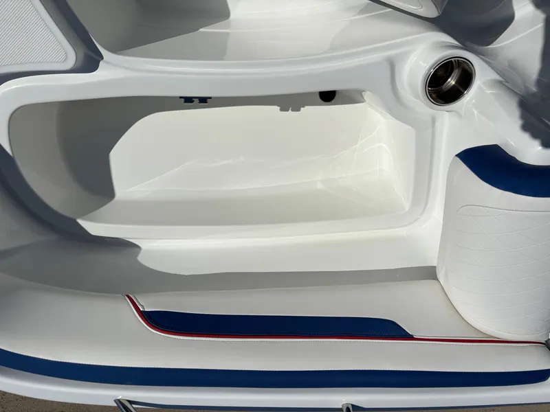 Slide: The Image of 2020 Tahoe 215 Xi boat interior with white and blue seating and storage compartment. - 14