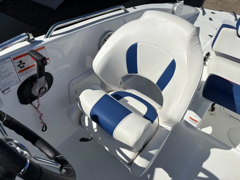 Slide: The Image of 2020 Tahoe 215 Xi boat seat with blue and white upholstery, featuring a steering wheel and control panel. - 17
