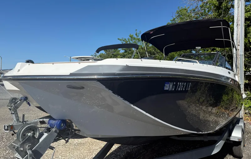 Slide: The Image of 2022 Glastron/Carlson GTD 220 boat on trailer, black and white design, sunny day. - 4