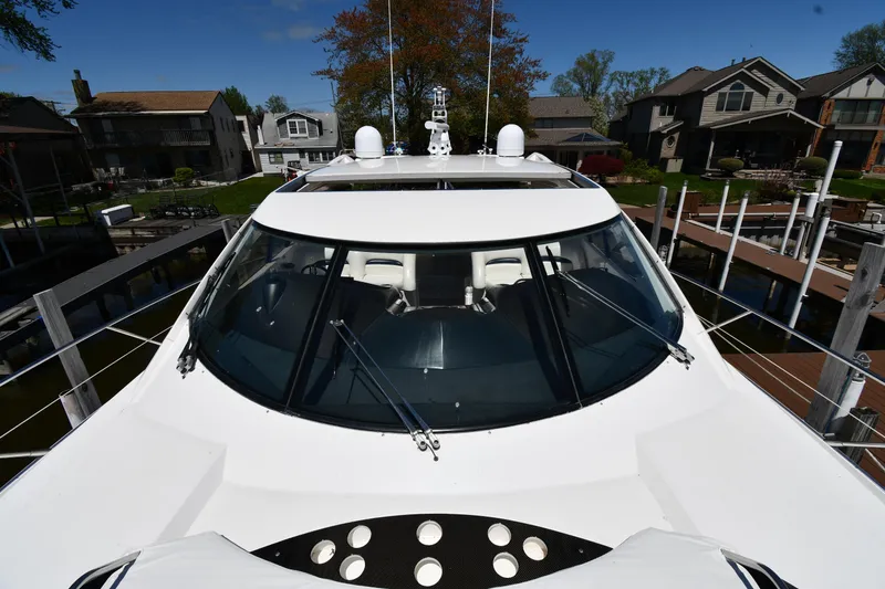 Slide: The Image of Front view of a 2002 Sunseeker 68 Predator yacht docked near waterfront homes. - 11
