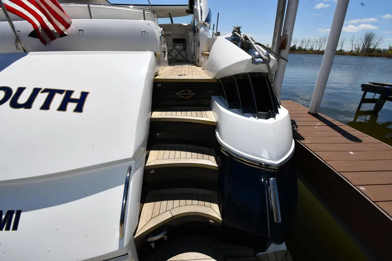 Slide: The Image of 2002 Sunseeker 68 Predator yacht docked, featuring elegant wooden steps and sleek design. - 14
