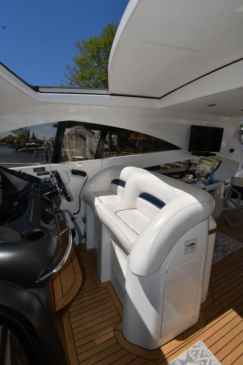 Slide: The Image of Interior view of 2002 Sunseeker 68 Predator yacht with white seating and wooden flooring. - 27