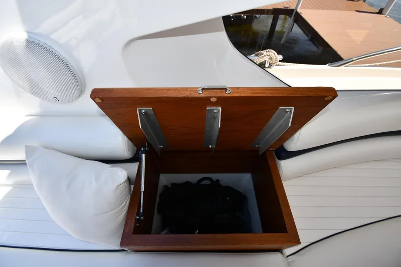 Slide: The Image of Sunseeker 68 Predator 2002 yacht interior with open wooden storage compartment and white seating. - 40