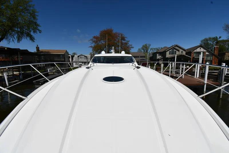 Slide: The Image of 2002 Sunseeker 68 Predator yacht docked, showcasing sleek design and spacious deck. - 9