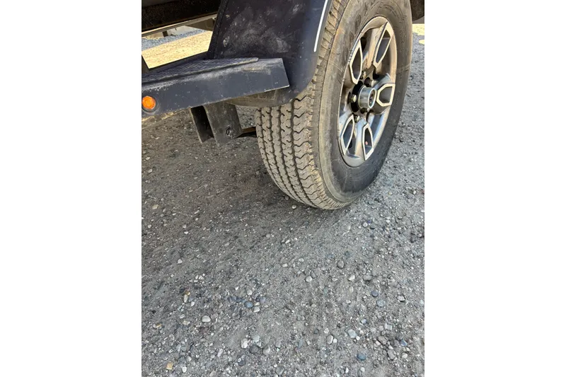 Slide: The Image of 2021 Tracker Pro Team 175 TX trailer wheel on gravel surface. - 10