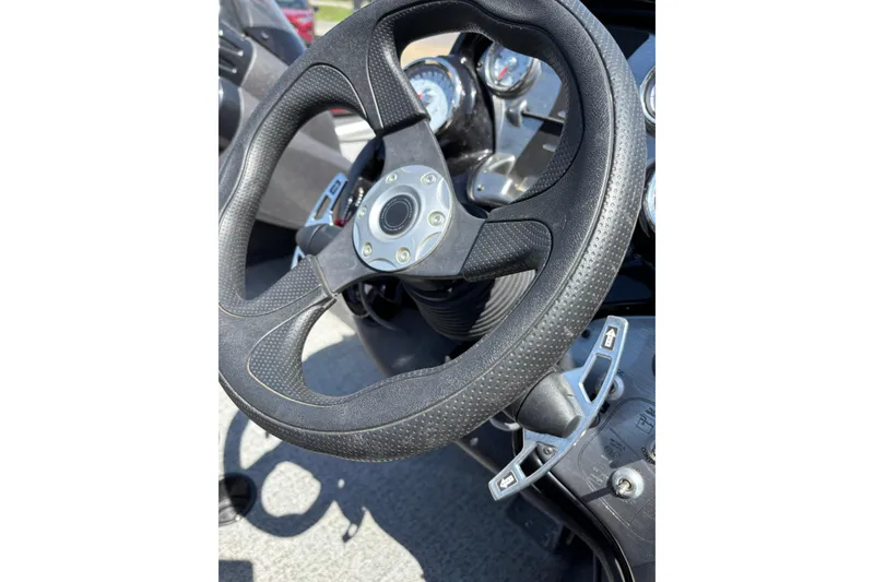 Slide: The Image of Steering wheel of 2021 Tracker Pro Team 175 TX boat, featuring control levers and gauges. - 6
