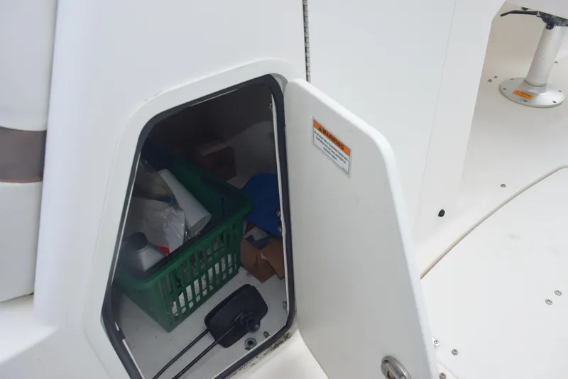 Slide: The Image of Open storage compartment on 2012 Hurricane SD2200 O/B boat with various items inside. - 19