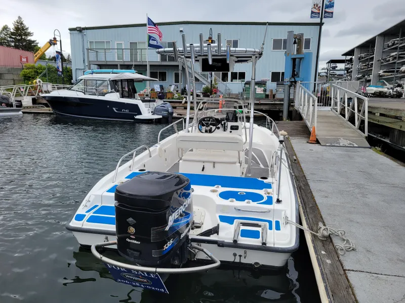 Slide: The Image of 2005 Boston Whaler 180 Dauntless boat docked at marina with outboard motor. - 4