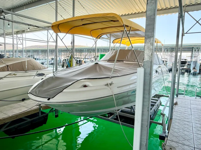Slide: The Image of 2002 Sea Ray 270 Sundeck boat with yellow canopy docked in marina. - 1