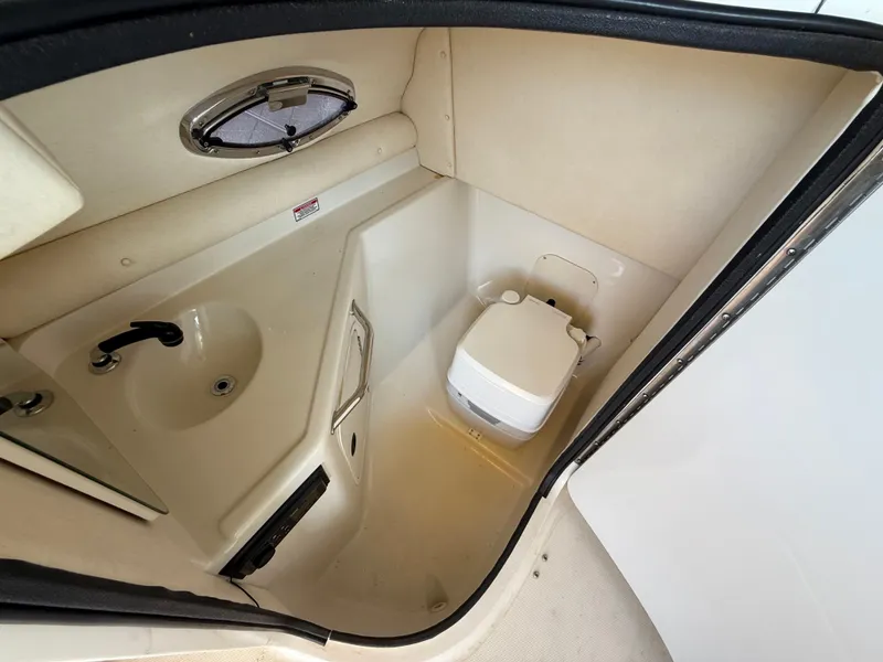 Slide: The Image of 2002 Sea Ray 270 Sundeck interior with compact bathroom and sink. - 12