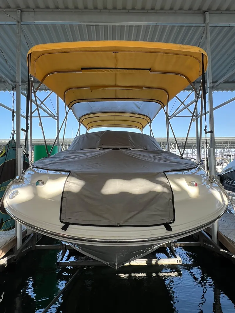 Slide: The Image of 2002 Sea Ray 270 Sundeck with yellow canopy docked under shelter. - 14