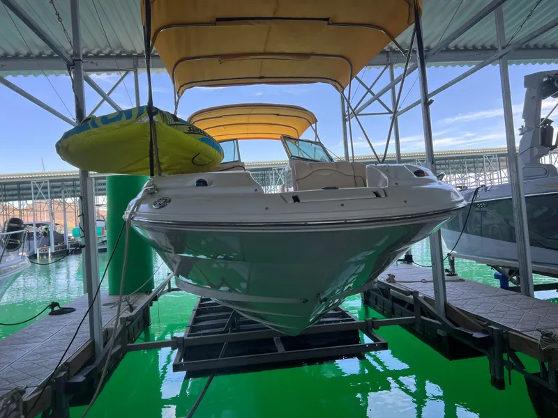 Slide: The Image of 2002 Sea Ray 270 Sundeck boat docked under canopy with yellow canopy and inflatable tube. - 18