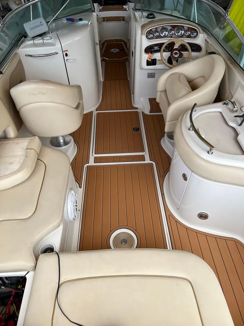 Slide: The Image of 2002 Sea Ray 270 Sundeck interior with beige seating and wood-style flooring. - 20
