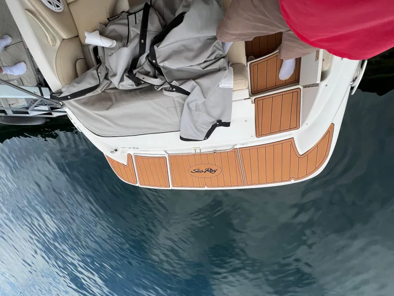 Slide: The Image of 2002 Sea Ray 270 Sundeck boat with teak deck, docked on calm water. - 21