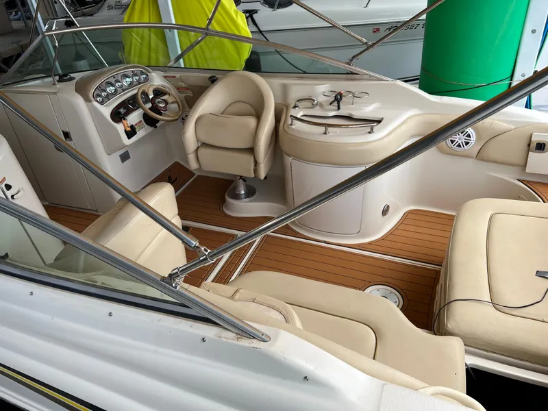 Slide: The Image of 2002 Sea Ray 270 Sundeck interior with beige seating and wood accents. - 22