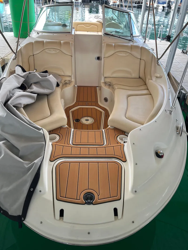 Slide: The Image of 2002 Sea Ray 270 Sundeck boat interior with tan seating and wooden flooring. - 23