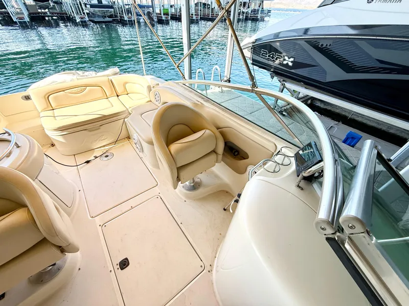 Slide: The Image of 2002 Sea Ray 270 Sundeck interior with seating, docked by the water. - 6