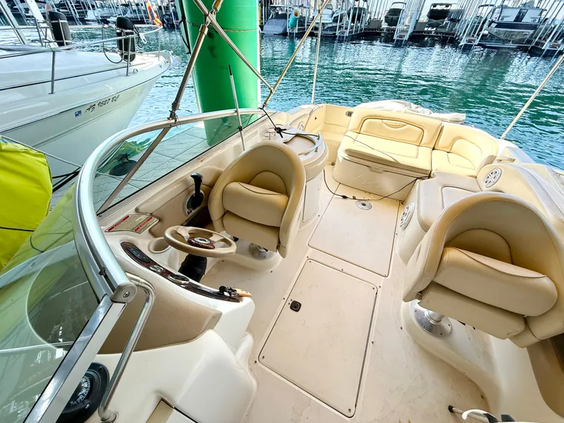 Slide: The Image of 2002 Sea Ray 270 Sundeck boat interior with beige seating and steering wheel. - 8