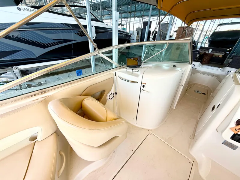 Slide: The Image of 2002 Sea Ray 270 Sundeck interior with beige seating and dashboard under a canopy. - 9