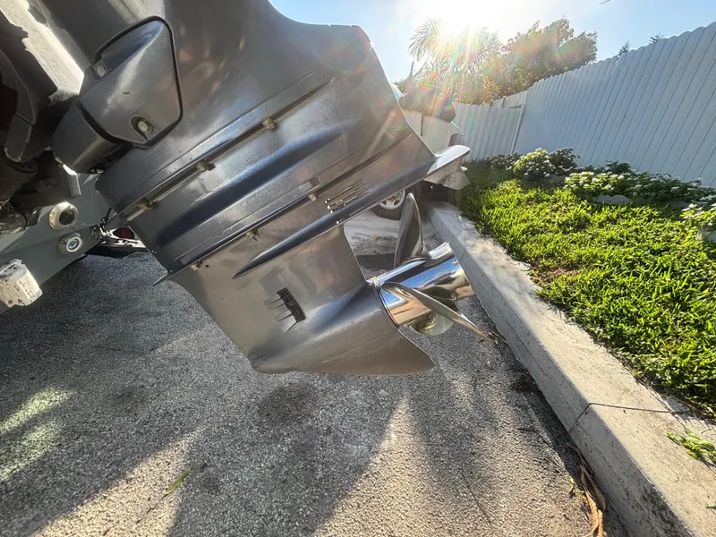 Slide: The Image of 2018 Key West 203 FS boat propeller in sunlight, parked on concrete near greenery. - 10