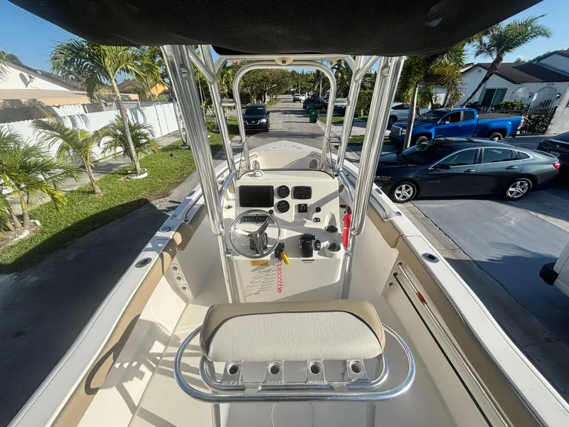 Slide: The Image of 2018 Key West 203 FS boat interior with steering console and seating, parked in a residential area. - 15