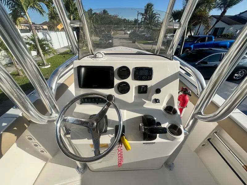 Slide: The Image of 2018 Key West 203 FS boat console with steering wheel and navigation controls. - 16