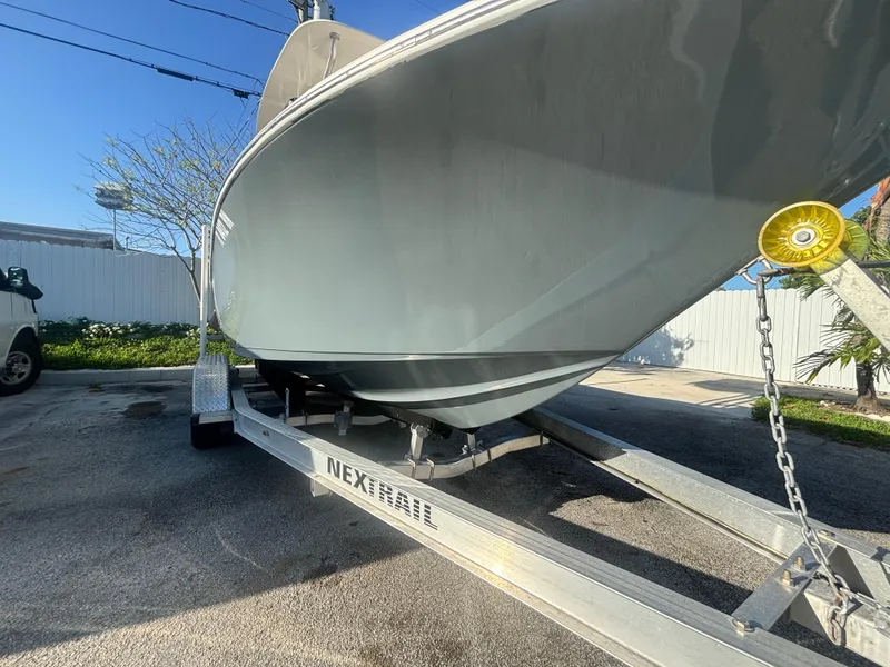 Slide: The Image of 2018 Key West 203 FS boat on trailer, parked outdoors under clear blue sky. - 2