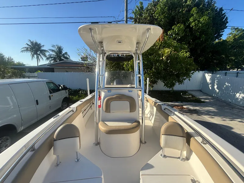 Slide: The Image of 2018 Key West 203 FS boat with seating, parked outdoors, surrounded by trees and a van. - 25