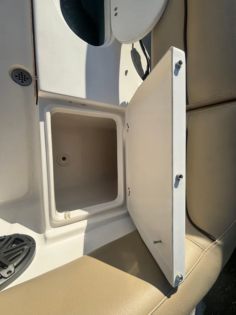 Slide: The Image of 2018 Key West 203 FS boat storage compartment with open hatch and beige seating. - 31