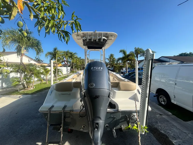 Slide: The Image of 2018 Key West 203 FS boat with outboard motor, parked in a sunny residential area. - 8