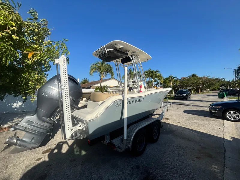 Slide: The Image of 2018 Key West 203 FS boat on trailer, parked outdoors under clear blue sky. - 9