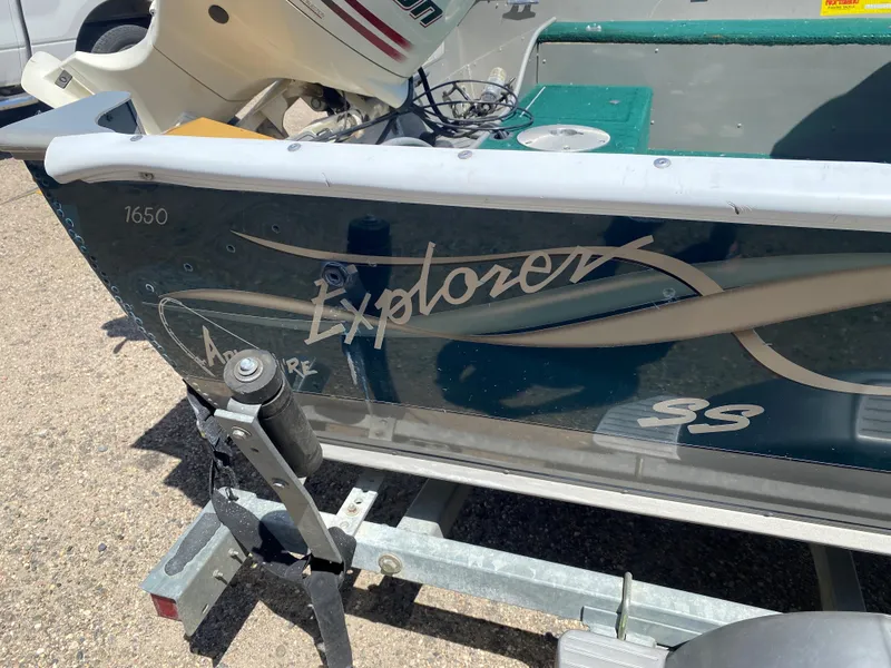 Slide: The Image of 2002 Lund 1650 Explorer boat on trailer, featuring outboard motor and green interior. - 23