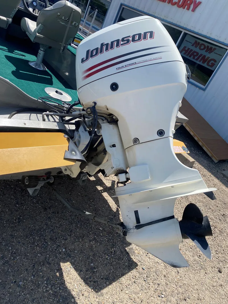 Slide: The Image of 2002 Lund 1650 Explorer boat with Johnson outboard motor, parked on gravel. - 9