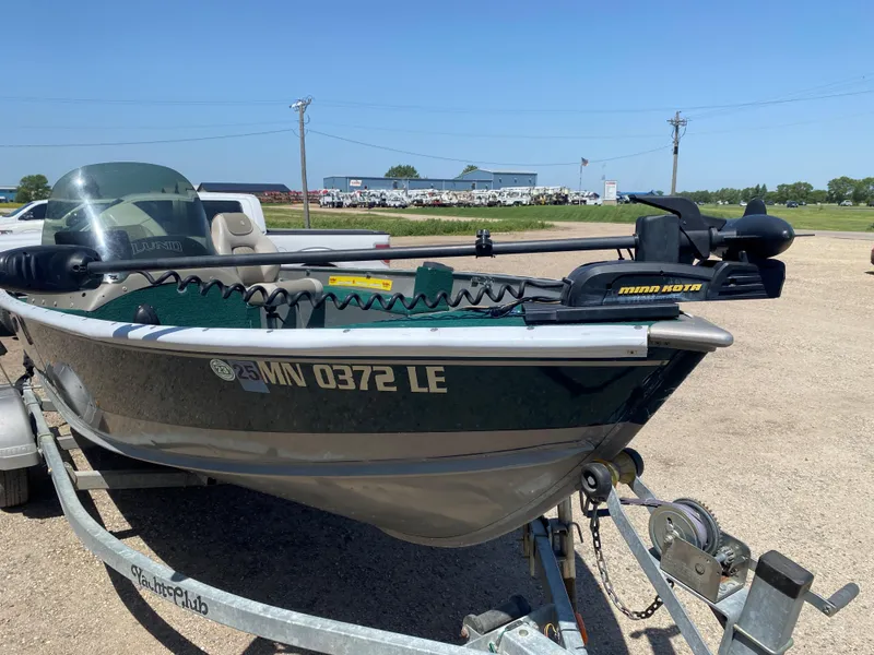 Slide: The Image of 2002 Lund 1650 Explorer boat on trailer with Minn Kota motor, parked outdoors. - 13