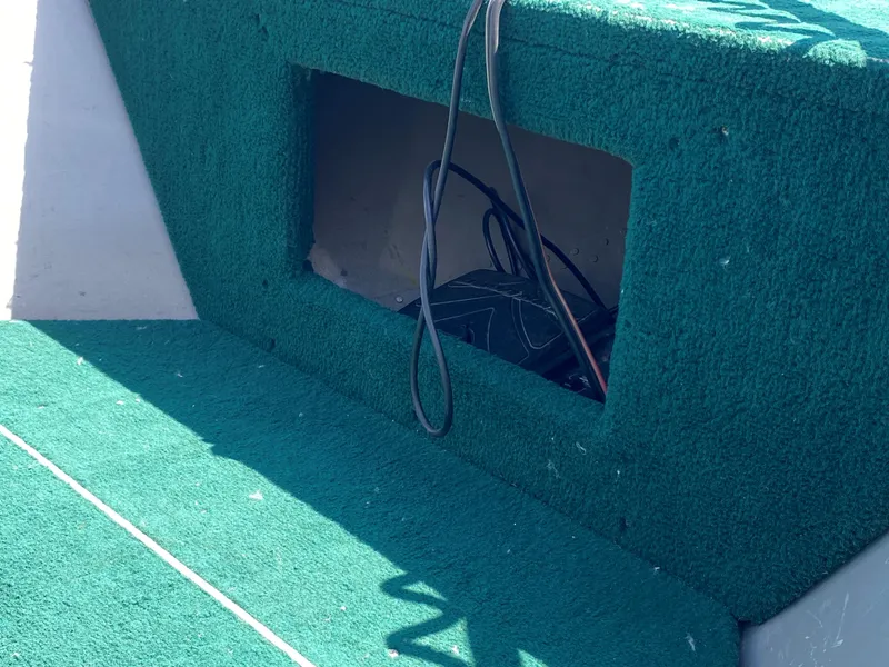 Slide: The Image of Green carpeted interior of a 2002 Lund 1650 Explorer boat with exposed wiring. - 15