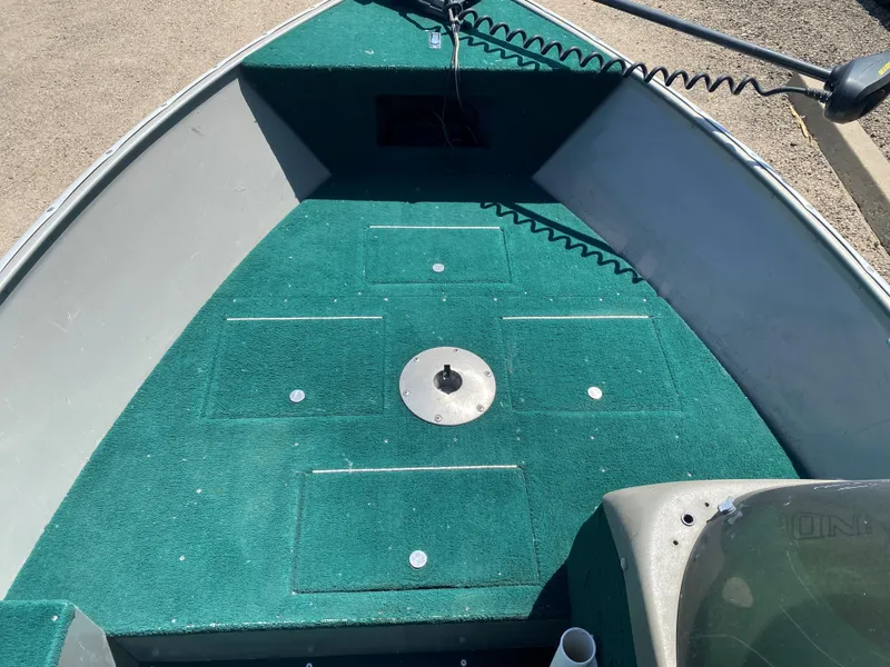 Slide: The Image of 2002 Lund 1650 Explorer boat interior with green carpet and storage compartments. - 17