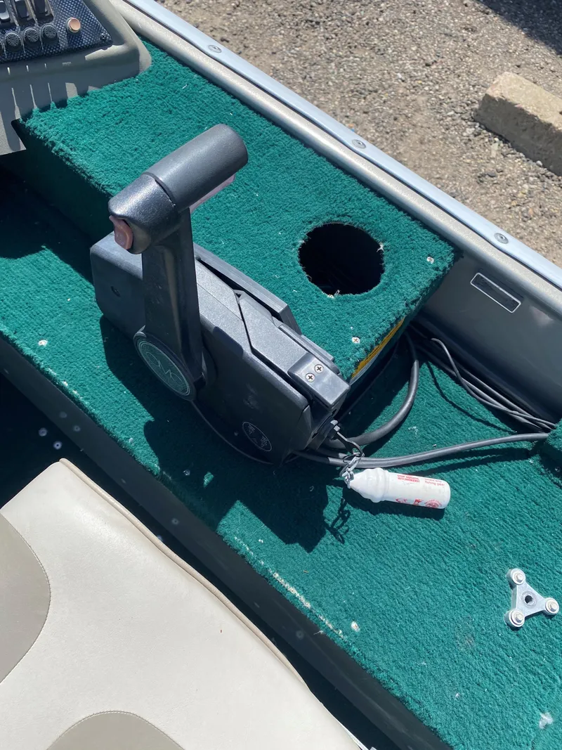 Slide: The Image of Control lever on a 2002 Lund 1650 Explorer boat with green carpeted surface. - 18