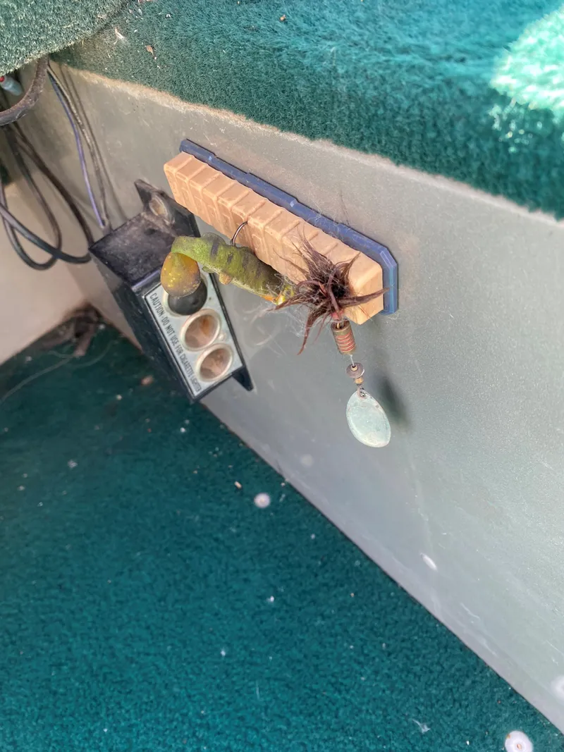 Slide: The Image of 2002 Lund 1650 Explorer interior with fishing lure and green carpet. - 19