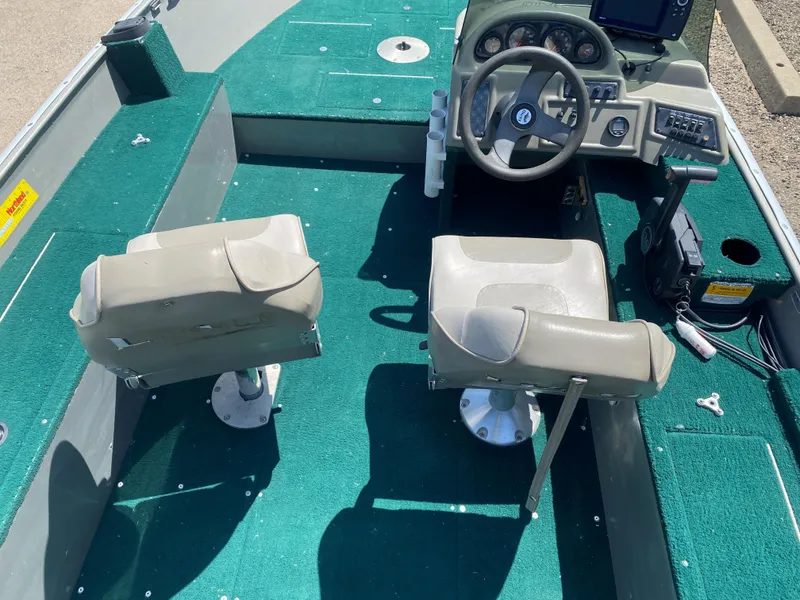 Slide: The Image of 2002 Lund 1650 Explorer boat interior with green carpet and dual seats. - 24