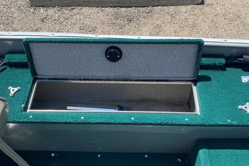 Slide: The Image of Open storage compartment on 2002 Lund 1650 Explorer boat with green carpet interior. - 27