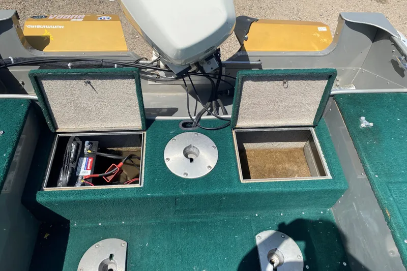 Slide: The Image of 2002 Lund 1650 Explorer boat interior with open storage compartments and battery. - 28